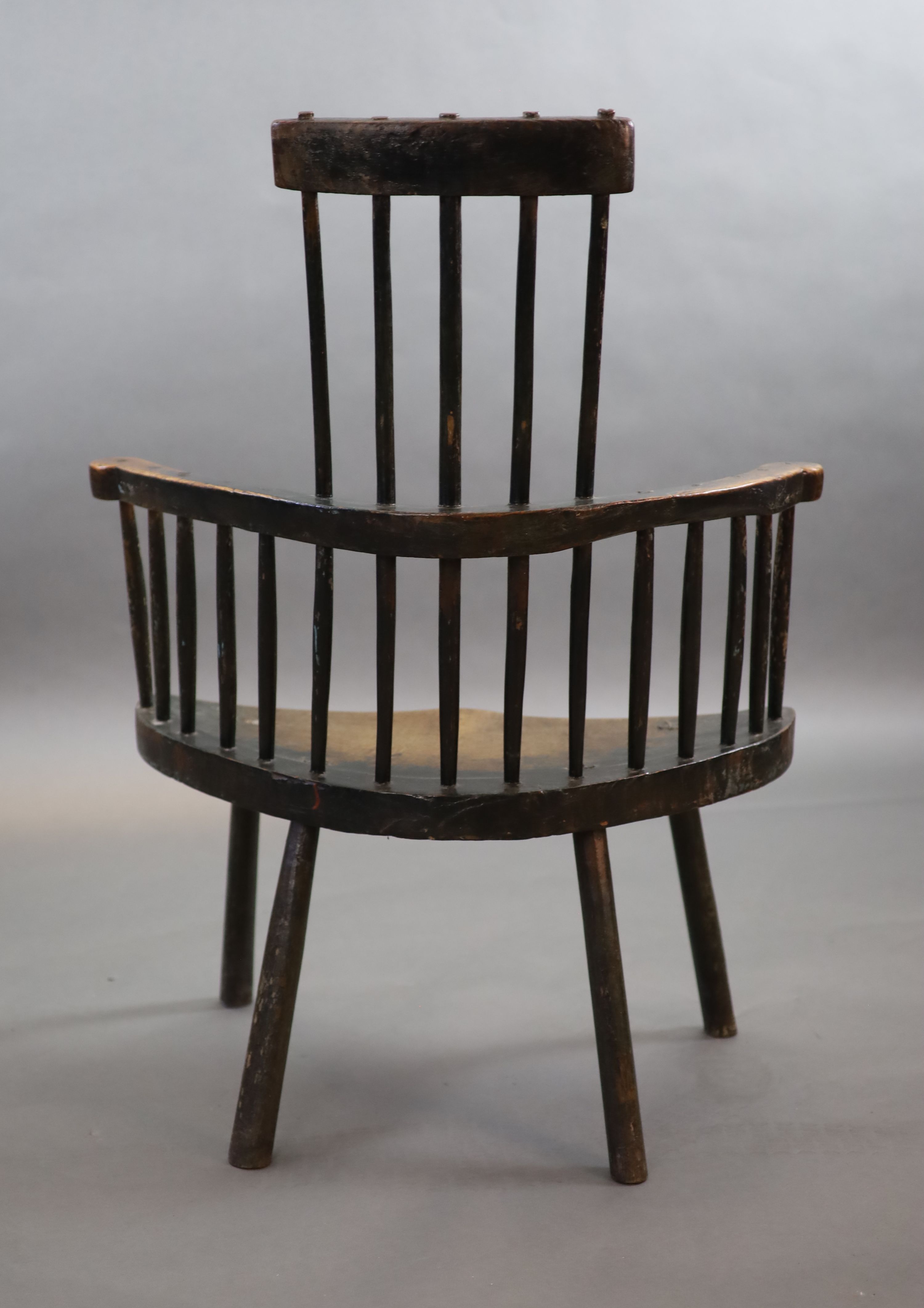 An 18th century primitive vernacular comb-back elbow chair, possibly Welsh, 70cm wide, 34cm deep, 99cm high.